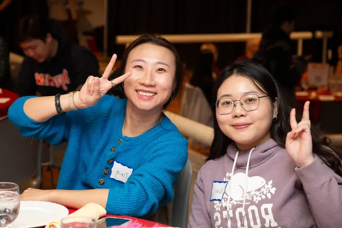 Two people putting up peace signs.